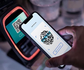 Smartphone scaning a QR code with payment details